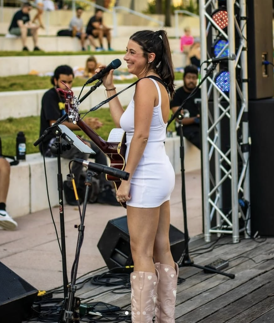 Leanne performing live on an outdoor stage in cowboy boots